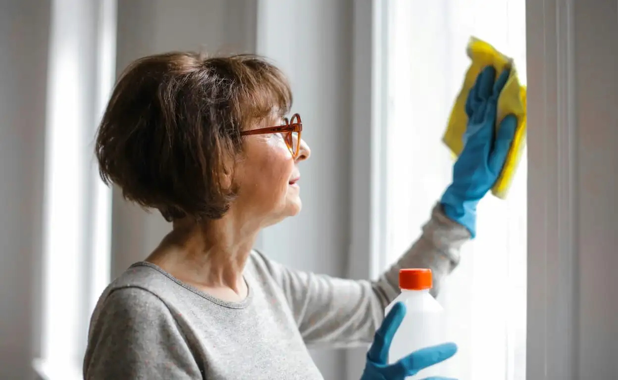 Oudere vrouw is aan het schoonmaken.