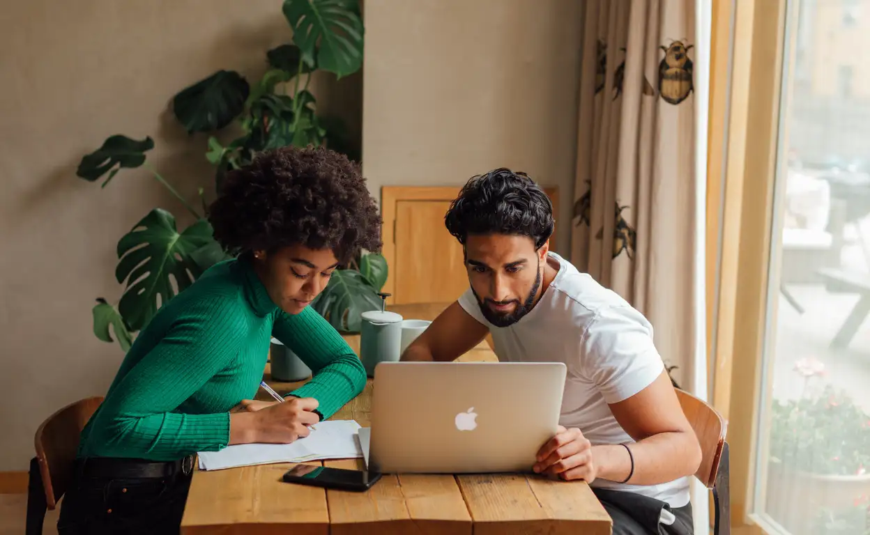 man en vrouw achter laptop