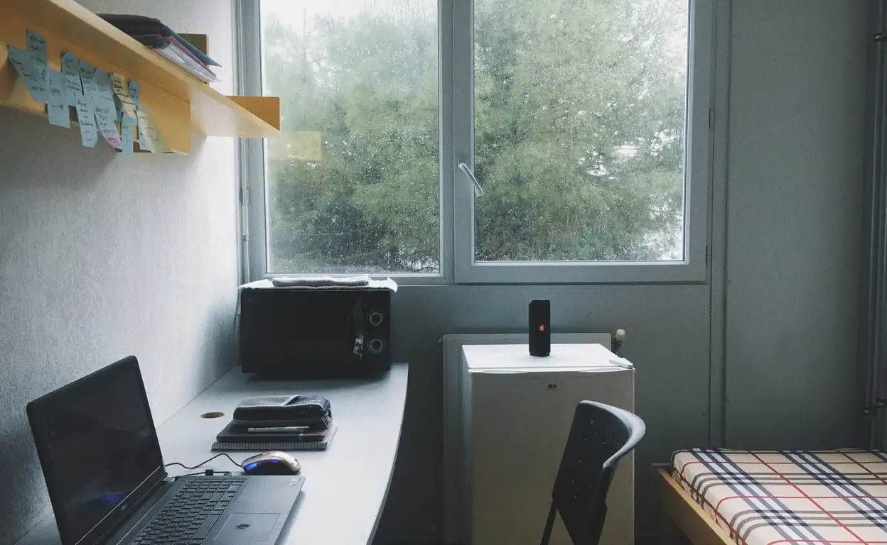Een studentenkamer met grijze lucht buiten