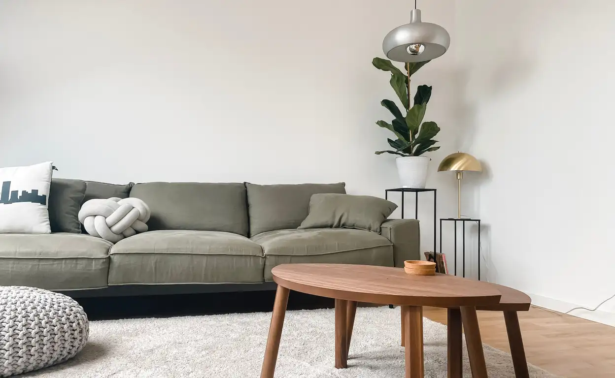 Een groene bank met houten bijzettafels
