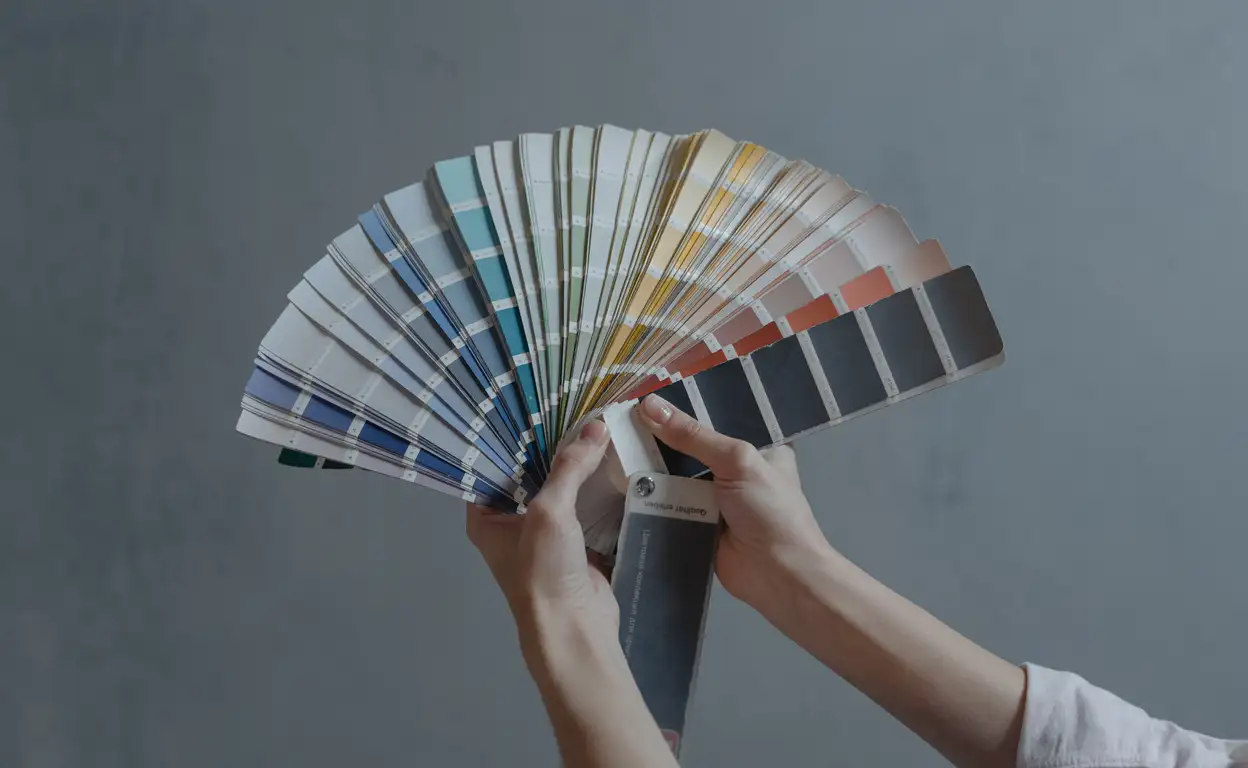 Een hand houdt een waaier aan verschillende kleuren en tinten vast