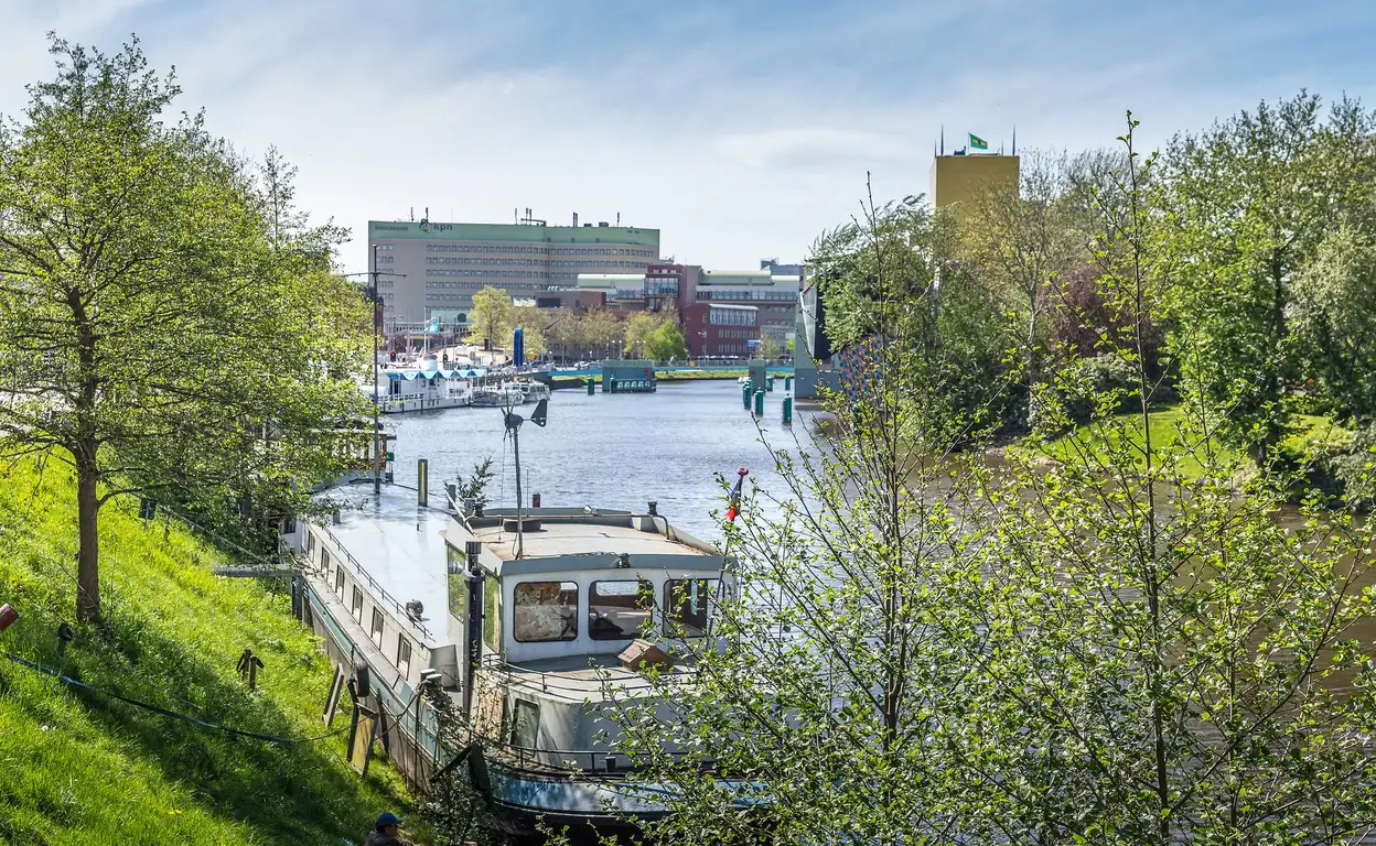 Foto van Groningen kijkend op het water en Groningen station