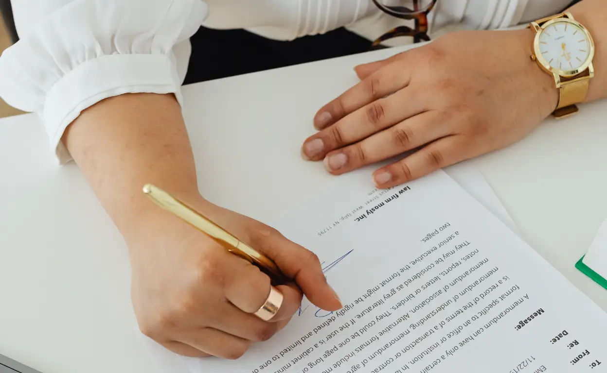 vrouw met een bril tekent een contract