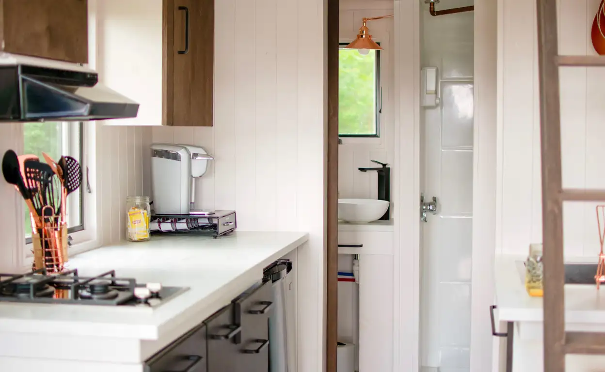 Een kleine keuken met daarachter een kleine badkamer