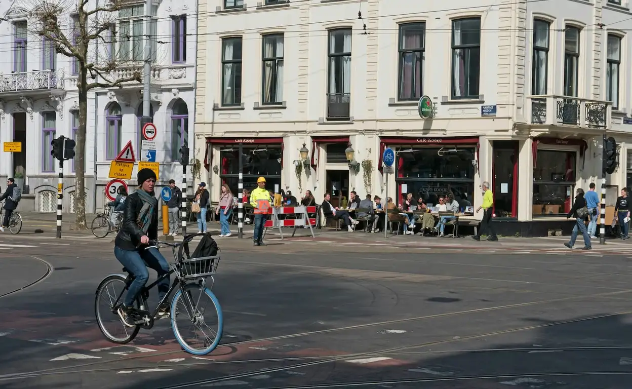 Een straat in Nederland met een overstekende fietser