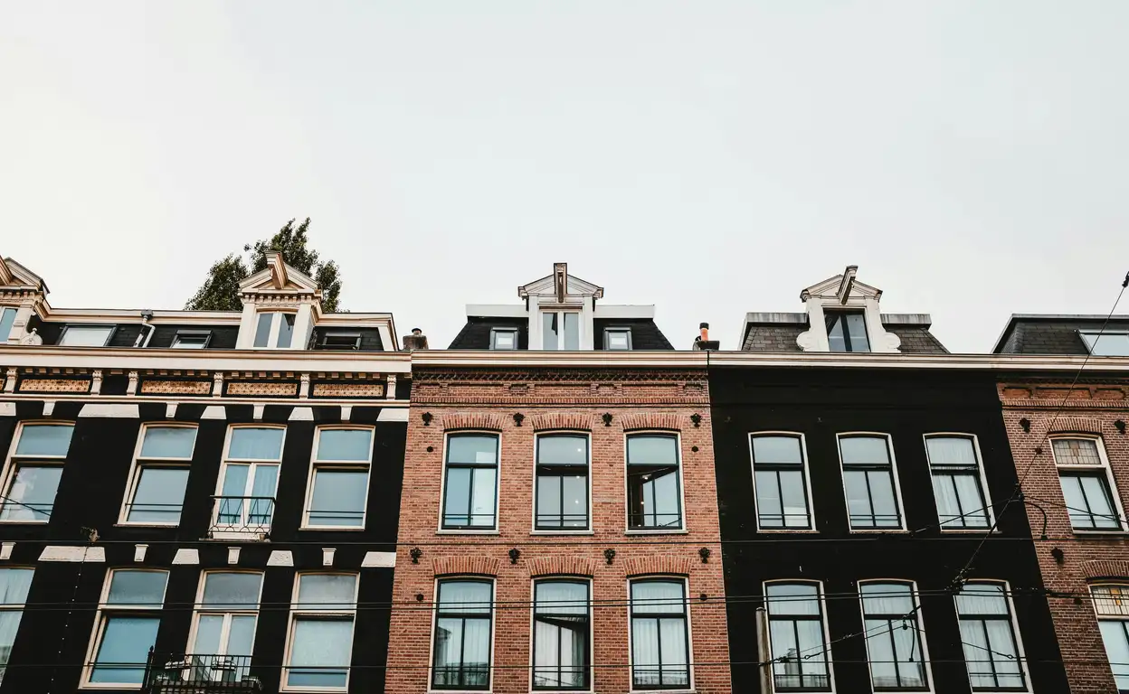 Rij met typische Nederlandse huizen in Amsterdam, de focus ligt op de ramen