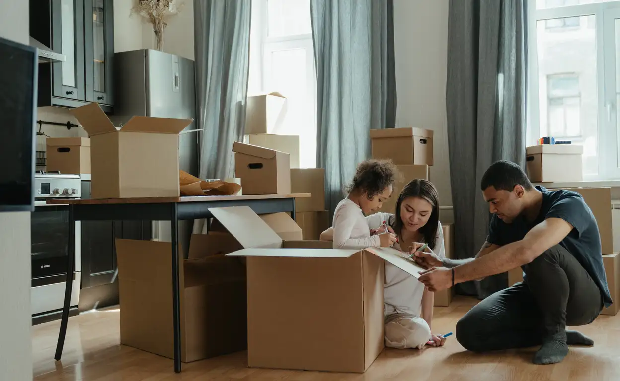 Een gezin is spullen aan het verhuizen. Er staan verhuisdozen om het gezin heem