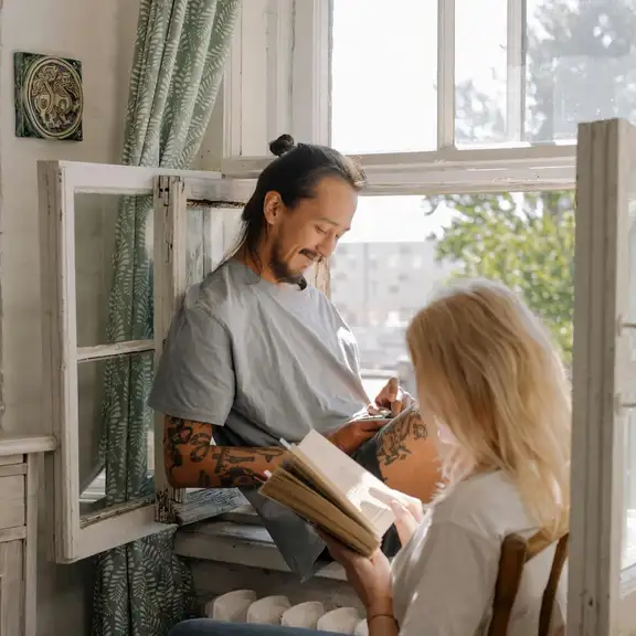 Man en vrouw kletsen bij een open raam