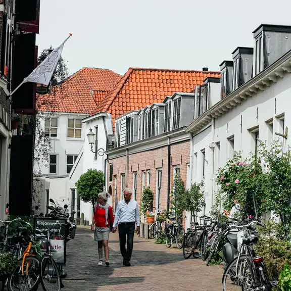 Een straat in Amersfoort met twee wandelende mensen en oude huisjes
