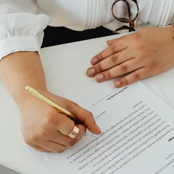 vrouw met een bril tekent een contract