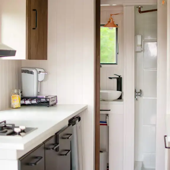 Een kleine keuken met daarachter een kleine badkamer