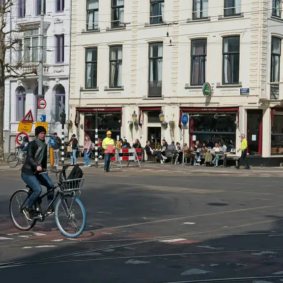 Een straat in Nederland met een overstekende fietser