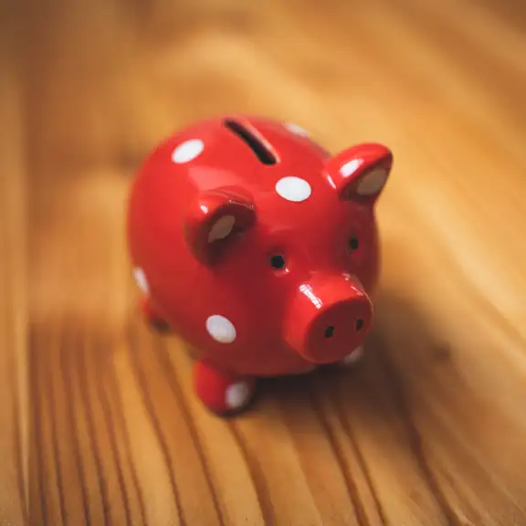 Een rood spaarvarken met witte stippen