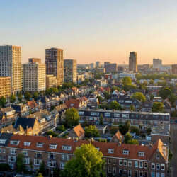 Panoramazicht op een Nederlandse stad bij zonsopgang, met een combinatie van traditionele laag en hoogbouw.