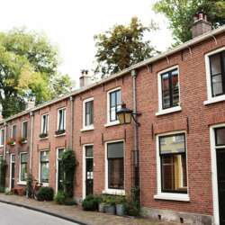 Rij met huurwoningen in Utrecht met bruine stenen en de bomen staan in bloei.