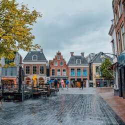 Plein in Leeuwarden met traditionele oud Nederlandse gebouwen aan de zijkant.