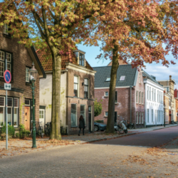 Een straat in Weesp in de herfst met aan de linkerkant oud hollandse huizen
